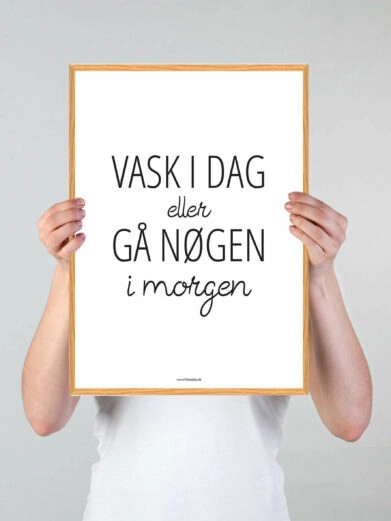 Vaskeplakat med teksten "Vask i dag eller gå nøgen i morgen" med sort skrift og egeramme