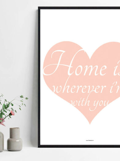 Close-up of the framed "Home is where..." poster. Features a pink heart with a white script quote. Stylish home decor.