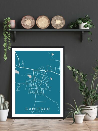 Gadstrup by plakat, a modern map art print in teal and white. Framed poster displayed with plants and decor. Sjælland, Denmark.