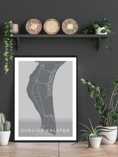 Sydlige Falster sort plakat: A grey map of Southern Falster, Denmark in a black frame, styled with plants on a wooden floor.