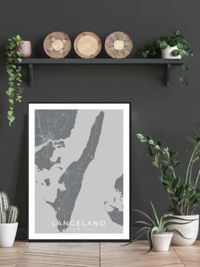 Langeland plakat in black frame showcasing a grey map of the Danish island, styled with plants and decorative baskets.