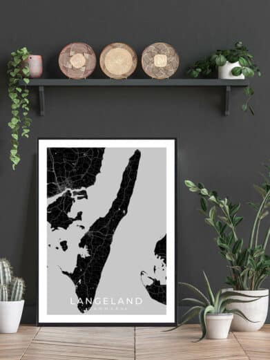 Black and white Langeland poster. Framed map art print featuring the Danish island, displayed with decorative plants and woven baskets.