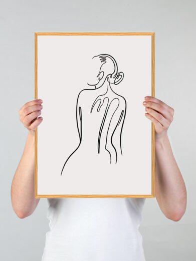 Line art poster featuring a minimalist black line drawing of a woman's back, held in a light wood frame, on sale.