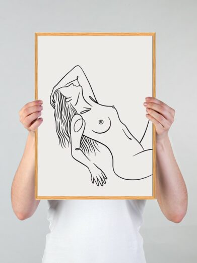 Stregtegnings plakat: Line art featuring a nude woman in black lines on a white background, framed in wood, held by a person.