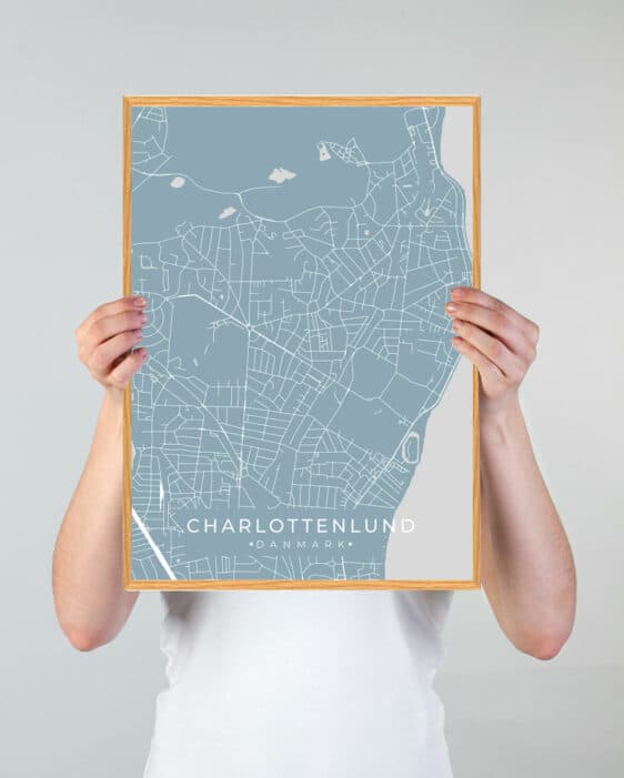Charlottenlund plakat i lyseblå med kort over byen, indrammet i træ. Detaljeret og stilfuldt design, perfekt til boligindretning.