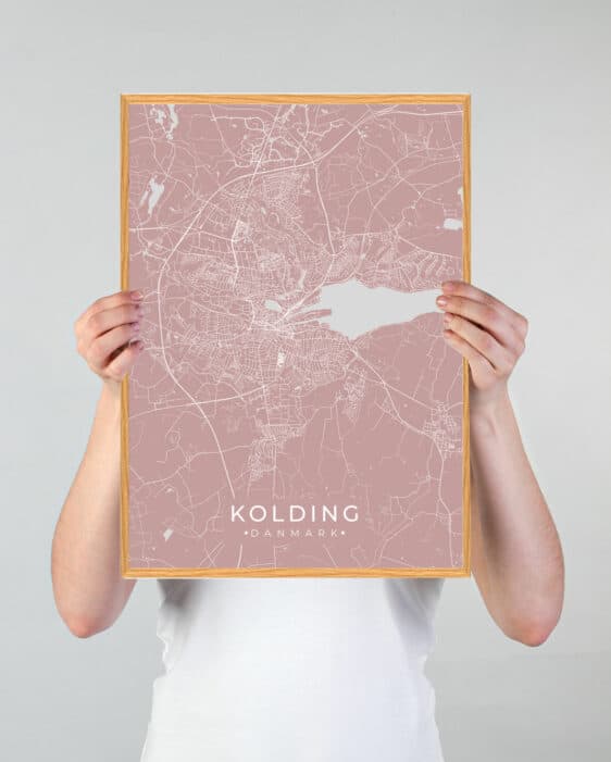 Kolding plakat i grøn by tema. Minimalistisk design med rosa kort over Kolding, Danmark, indrammet i træ. Moderne og stilfuld.