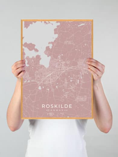 Roskilde byplakat i rosa: Et detaljeret kort over Roskilde, Sjælland, i en stilfuld rosa farve med hvide linjer og en træramme.