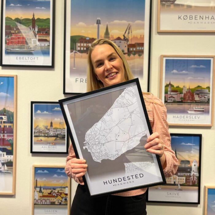 Kvinde, der holder en byplakat foran en hel væg fyldt med byplakater